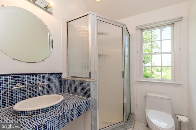 full bath with a stall shower, a sink, toilet, and tile patterned floors