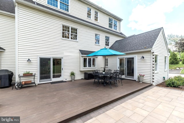 back of property featuring a deck and outdoor dining area