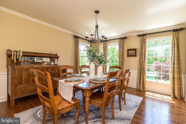 dining room featuring a chandelier, crown molding, wood finished floors, and baseboards