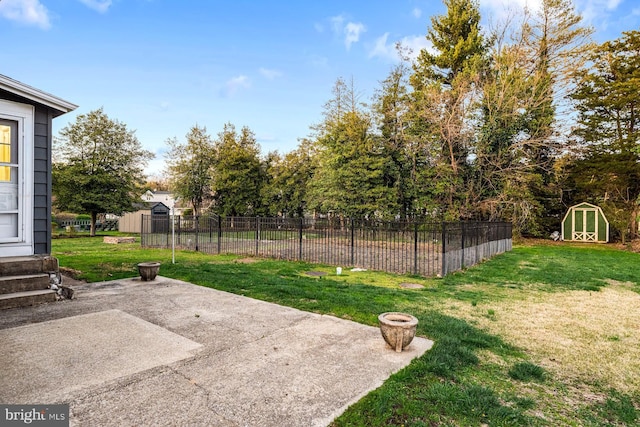 view of yard with a patio area, fence, a storage unit, and an outbuilding