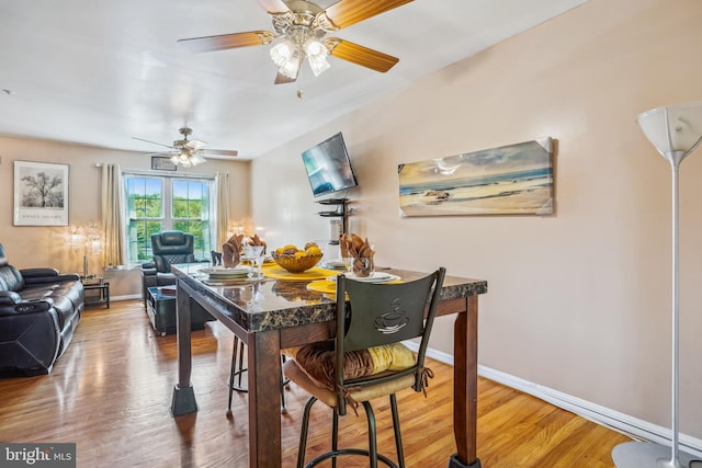 dining room with baseboards, wood finished floors, and ceiling fan