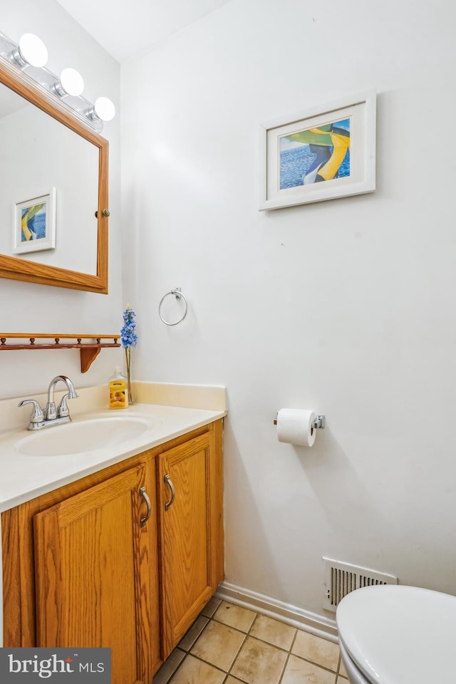 half bathroom featuring tile patterned floors, visible vents, toilet, and vanity