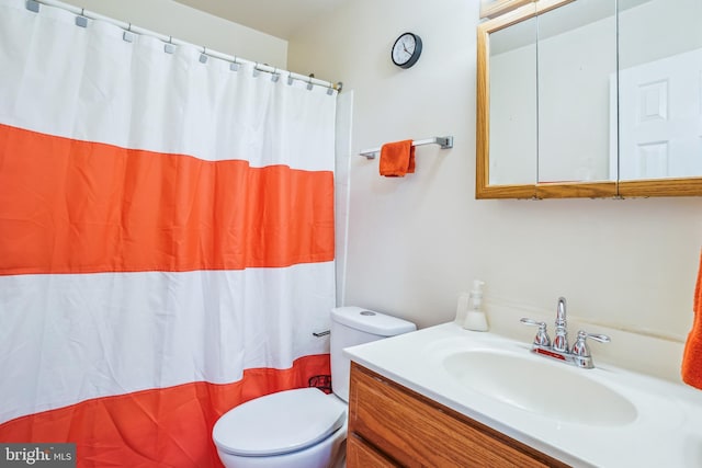 bathroom featuring toilet, vanity, and a shower with shower curtain