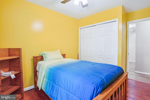 bedroom featuring dark wood finished floors, baseboards, ceiling fan, and a closet