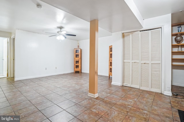 unfurnished living room featuring ceiling fan, tile patterned floors, and baseboards