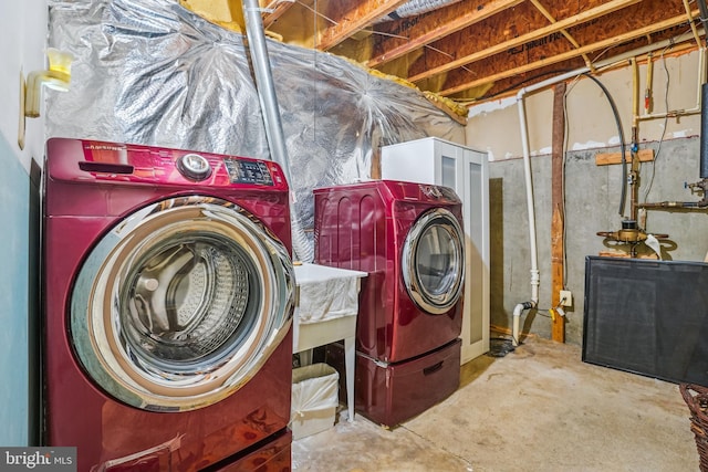 clothes washing area featuring separate washer and dryer and laundry area