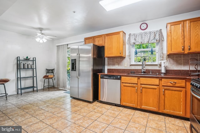 kitchen with a sink, backsplash, stainless steel appliances, and a healthy amount of sunlight