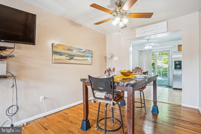 dining space with baseboards, wood finished floors, and a ceiling fan