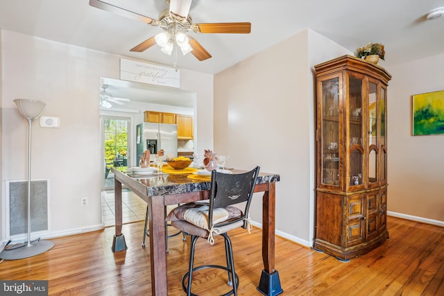 dining area featuring visible vents, ceiling fan, baseboards, and light wood-type flooring