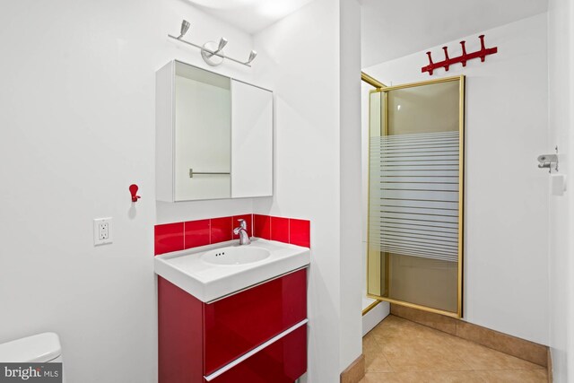 full bathroom with toilet, vanity, a shower stall, and tile patterned flooring