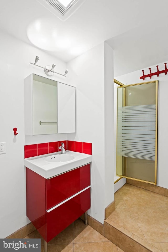 full bathroom with tile patterned floors, vanity, a shower stall, and baseboards