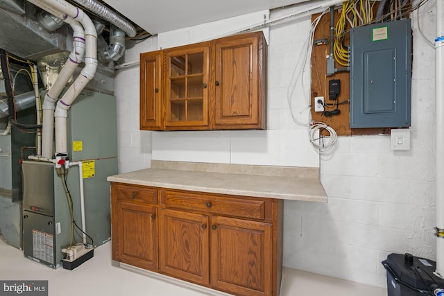 utility room featuring heating unit and electric panel