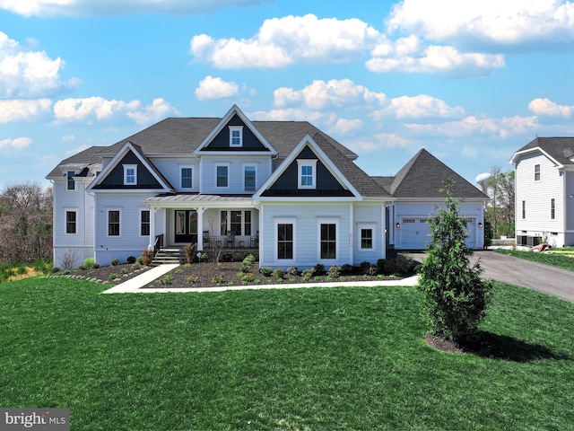 craftsman-style house with a porch, an attached garage, driveway, and a front lawn