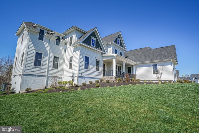 craftsman-style home featuring a porch, a front lawn, and central AC