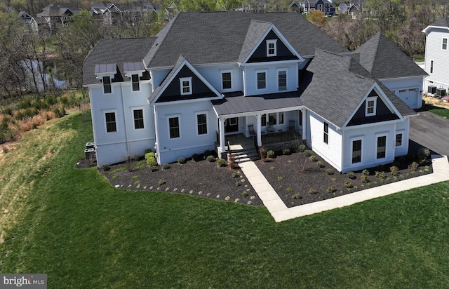view of front of property with covered porch, a residential view, and a front lawn