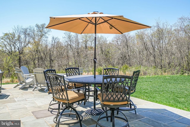 view of patio featuring outdoor dining space and a view of trees
