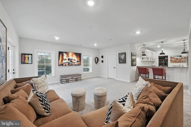 living room featuring light colored carpet, baseboards, and recessed lighting