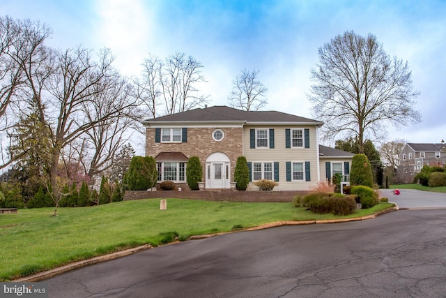 view of front of home featuring a front yard and brick siding