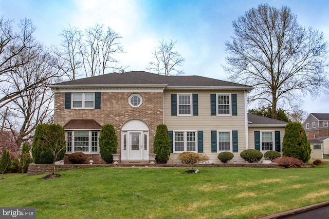 view of front of house featuring brick siding and a front lawn