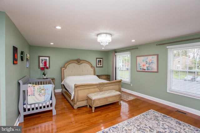 bedroom with recessed lighting, light wood-type flooring, visible vents, and multiple windows