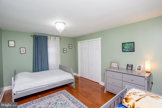 bedroom featuring wood finished floors, a closet, and baseboards