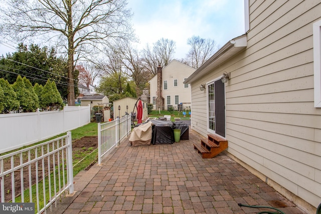 view of patio with a storage shed, entry steps, fence, and an outdoor structure