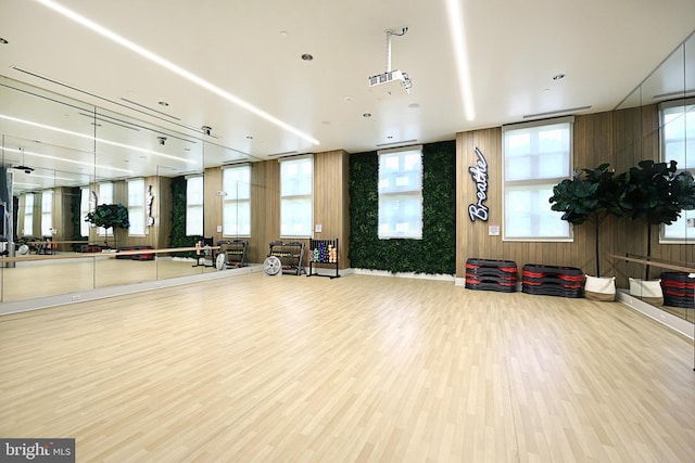 exercise room with wood finished floors and wooden walls