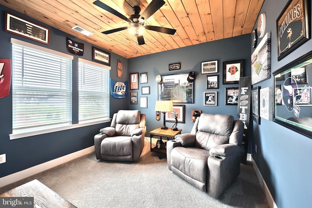 living area featuring baseboards, carpet flooring, visible vents, ceiling fan, and wooden ceiling