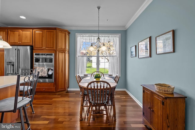 dining room with a chandelier, dark wood-style flooring, baseboards, and ornamental molding