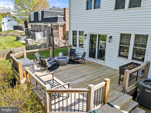 wooden terrace featuring an outdoor fire pit, cooling unit, and fence