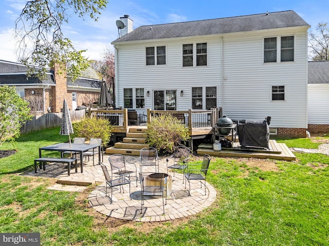 back of property with a patio, a chimney, an outdoor fire pit, a yard, and fence