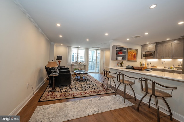 living room featuring visible vents, baseboards, dark wood finished floors, crown molding, and recessed lighting