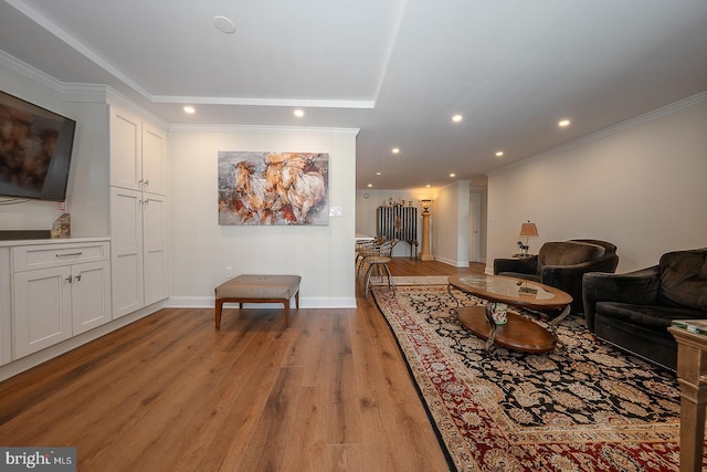 living area with baseboards, recessed lighting, light wood-type flooring, and ornamental molding