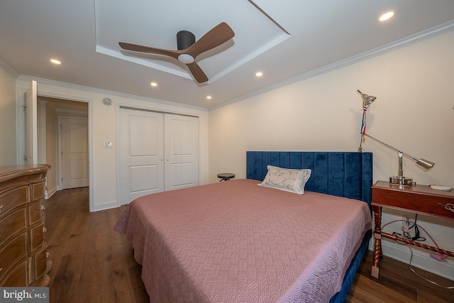 bedroom featuring a tray ceiling, crown molding, wood finished floors, and recessed lighting