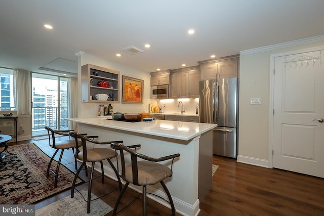 kitchen featuring a kitchen breakfast bar, dark wood-style floors, open shelves, visible vents, and appliances with stainless steel finishes