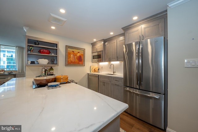 kitchen featuring appliances with stainless steel finishes, recessed lighting, open shelves, dark wood finished floors, and a sink