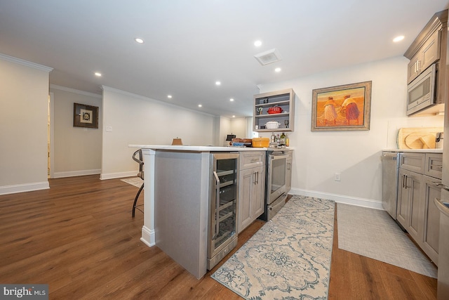 kitchen with crown molding, appliances with stainless steel finishes, baseboards, and beverage cooler