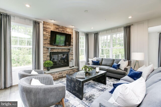 living area featuring recessed lighting, a fireplace, and light wood finished floors