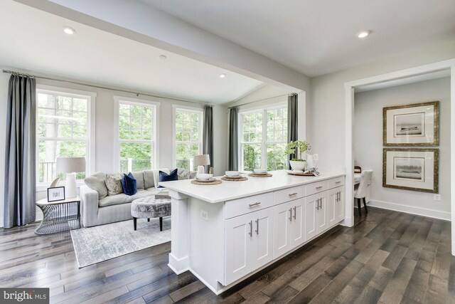 kitchen featuring lofted ceiling, recessed lighting, white cabinetry, light countertops, and dark wood finished floors