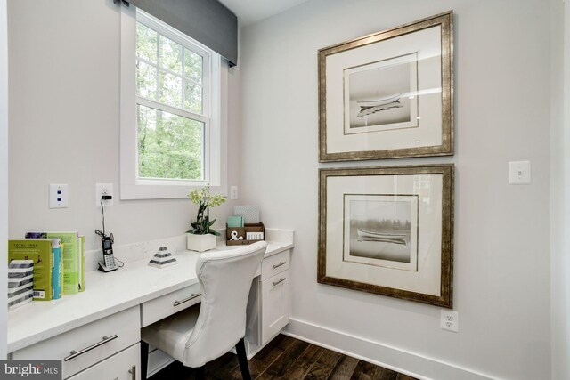 office area with built in desk, baseboards, and dark wood-style floors