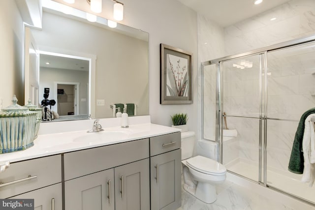 bathroom with a shower stall, vanity, marble finish floor, and toilet