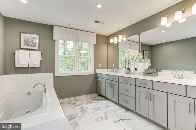 full bathroom featuring a garden tub, visible vents, marble finish floor, a sink, and double vanity