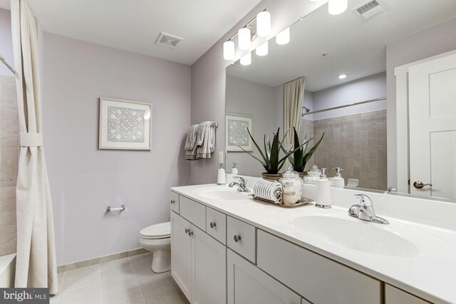 bathroom featuring toilet, a sink, tile patterned flooring, and visible vents