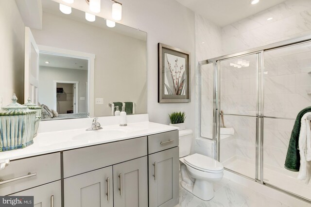 bathroom featuring toilet, a shower stall, recessed lighting, vanity, and marble finish floor