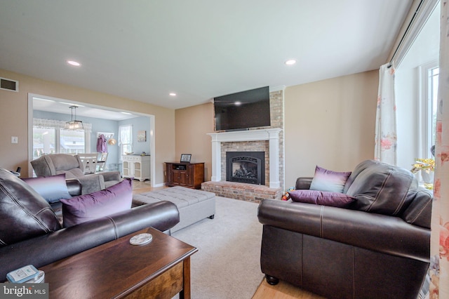 living room featuring baseboards, visible vents, recessed lighting, wood finished floors, and a fireplace
