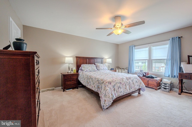 bedroom featuring light carpet, a ceiling fan, visible vents, and baseboards