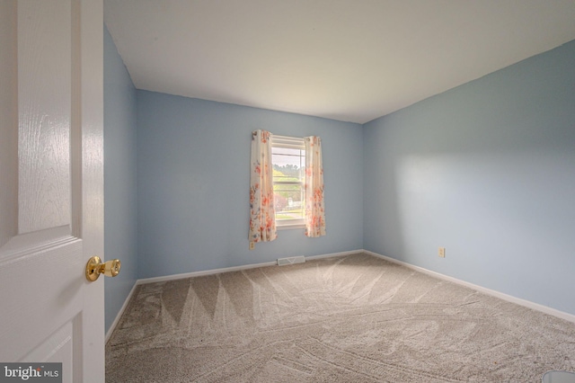 carpeted spare room with baseboards and visible vents
