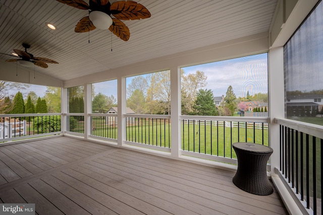 wooden terrace with a ceiling fan and a yard