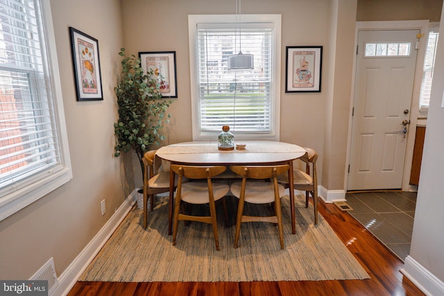 dining area with wood finished floors, baseboards, and visible vents