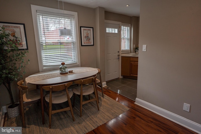 dining space with baseboards and dark wood-style floors